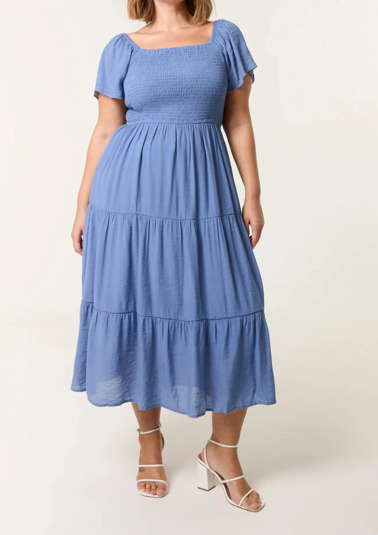 Woman wearing a blue dress with a plain background